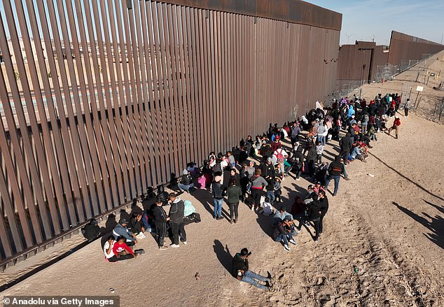 Groups of migrants of different nationalities arrive at the border wall before crossing into the US near El Paso