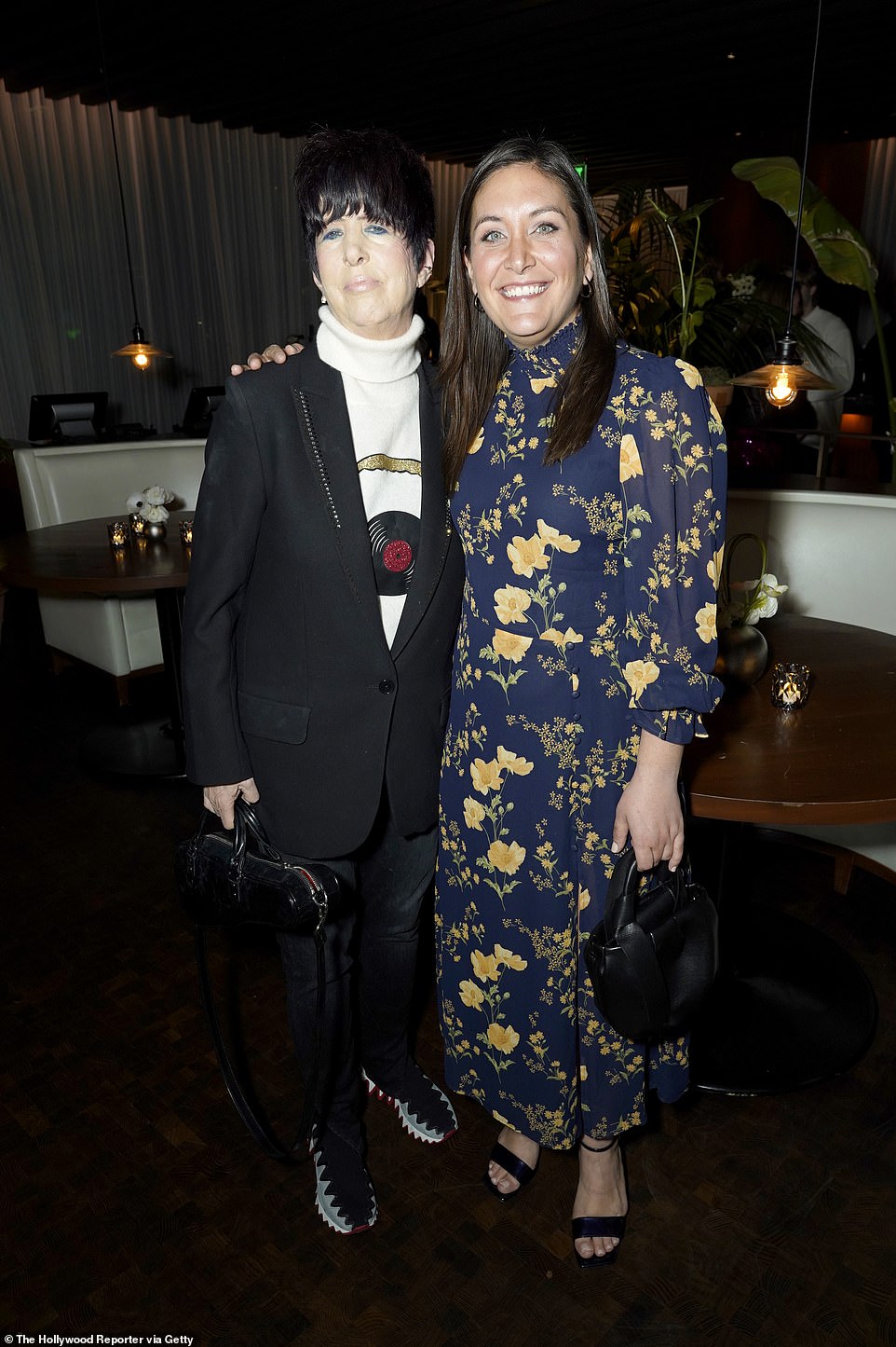 Acclaimed songwriter Dianne Warren showcased her unique style in a black suit with a white turtleneck alongside Karen Ryan in a blue and yellow floral dress.