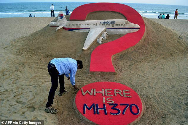 Indian sand artist Sudarsan Pattnaik creates a sand sculpture of the missing Malaysia Airlines flight MH370 on Puri beach in the eastern state of Odisha on March 7, 2015.