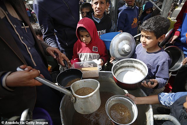 Palestinians queue for hours to receive food distributed by charitable organizations, in Deir Balah, Gaza, on March 1, 2024.