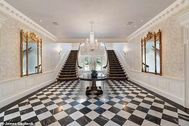 Pictured: The double staircase and checkered-floor foyer that guests see upon entering the home.