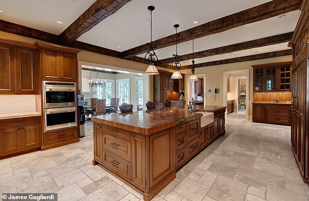 The spacious kitchen contains a large center island, marble counters and top-of-the-line appliances.