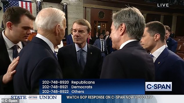 Biden's bodyman Jacob Spreyer (left) leans in to warn the president about the hot microphone.