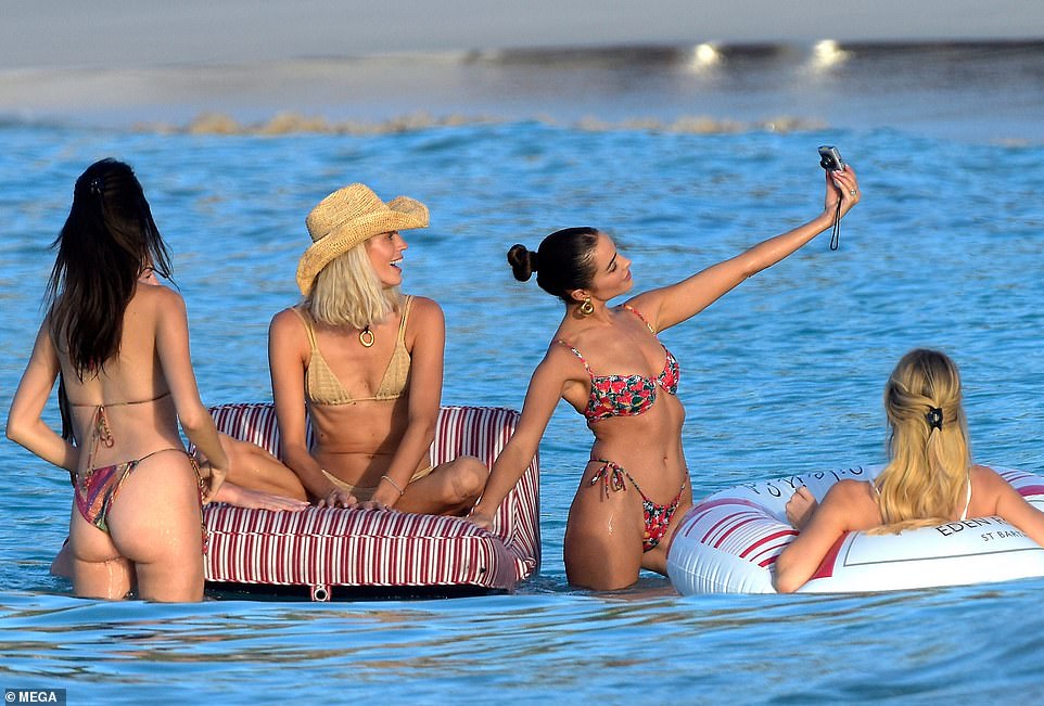 The models were accompanied by their friends as they lounged on the beach and took selfies together in the water.