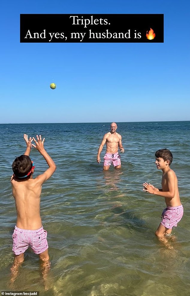Bec also posted a photo of her husband Chris Judd playing catch in shallow water with two of their children.
