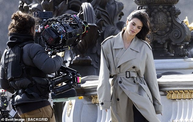 In front of a monument, Kendall tilted her head to the side as a camerawoman held a huge camera just inches from her face.