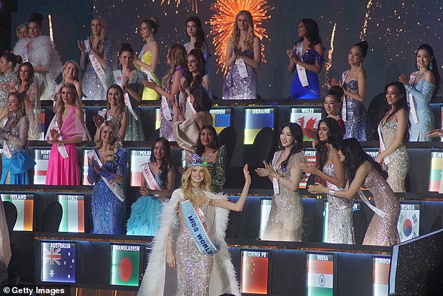 Miss World 2024 looks glamorous while greeting the other contestants who applaud her
