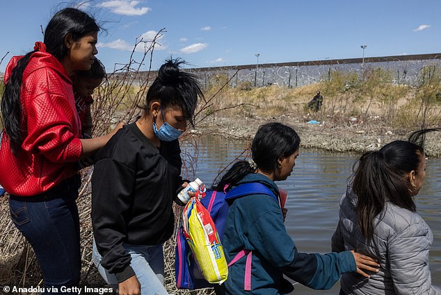 Migrants cross the Rio Grande to surrender to US authorities in El Paso, Texas