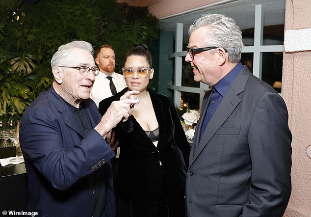 The duo looked happier than ever at the star-studded event ahead of the 2024 Oscars (pictured chatting with Danny Huston)