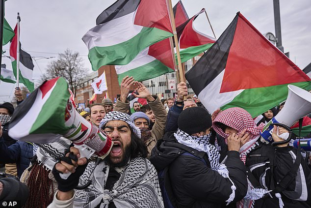 Demonstrators wave Palestinian flags and lead chants outside the Holocaust museum