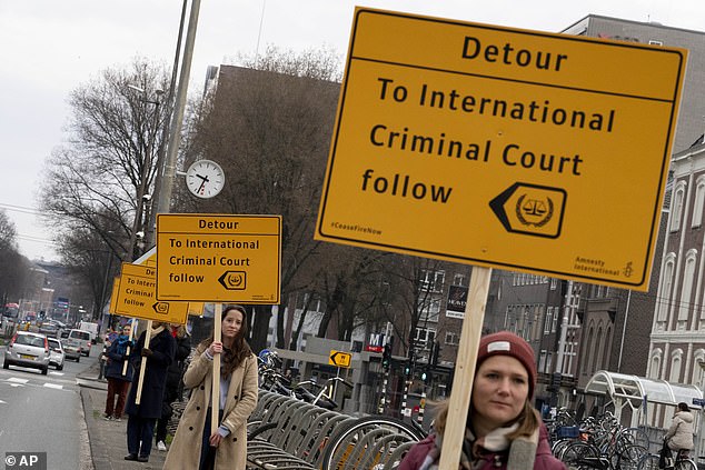 Protesters were seen walking around with placards reading: 'Detour to the International Criminal Court' along the route.