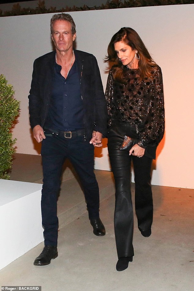 Nineties supermodel Cindy Crawford wore a sparkly black sweater to the star-studded pre-Oscars party as she held hands with her husband of 25 years, Casamigo co-founder Rande Gerber