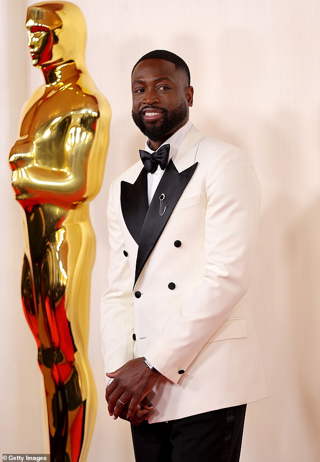 Former NBA star Dwyane Wade opted for a similar look with a double-breasted blazer and brooch