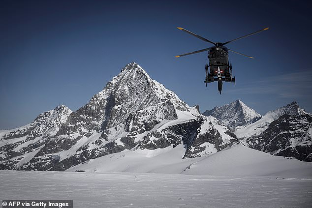 A Swiss Air Force helicopter is seen flying over the Tete Blanche high pass between Zermatt and Arolla, surrounded by the Swiss Alps