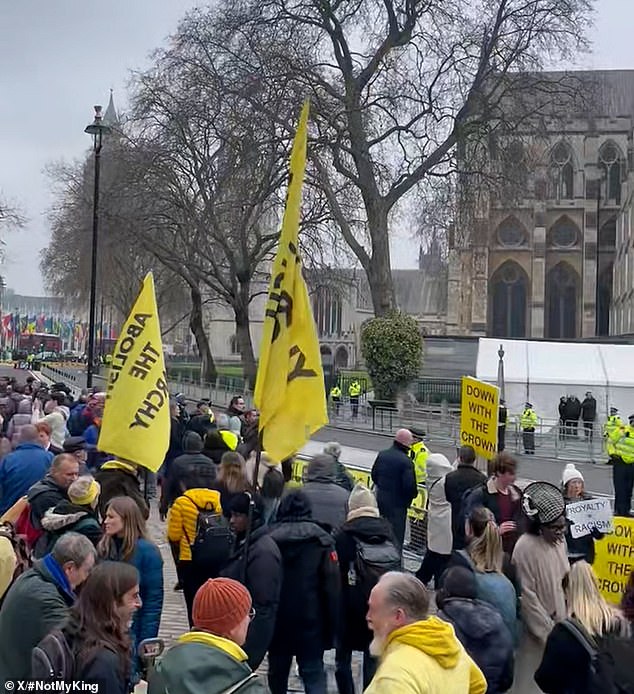 The large crowd with yellow banners and flags stood outside the abbey while the ceremony marking 75 years of the Commonwealth took place inside.