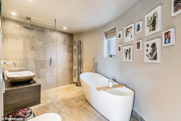 There are three bathrooms, including this one with a large shower and modern towel rack.