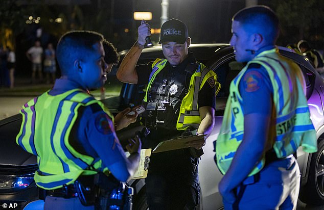 Officers work a DUI checkpoint near 5th Street and Meridian Avenue during spring break, Friday, March 8, 2024, in Miami Beach, Fla.