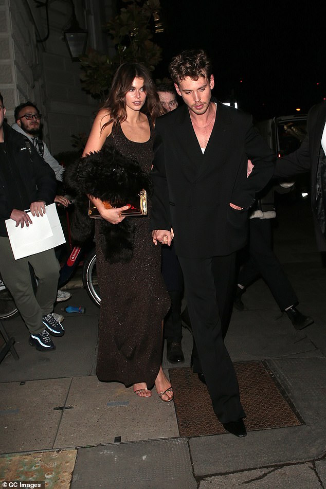 Kaia was seen wearing a sleeveless black maxi dress with a smart coat in hand as she held hands with Austin;  pictured February 15 in London