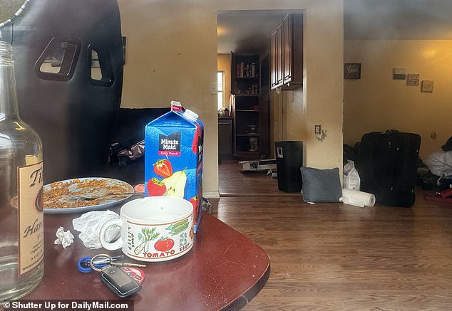 A half-finished meal, empty vodka bottle and open carton of juice sit on a table inside a house in Amityville, New York, that was raided Monday in connection with the discovery of two dismembered bodies