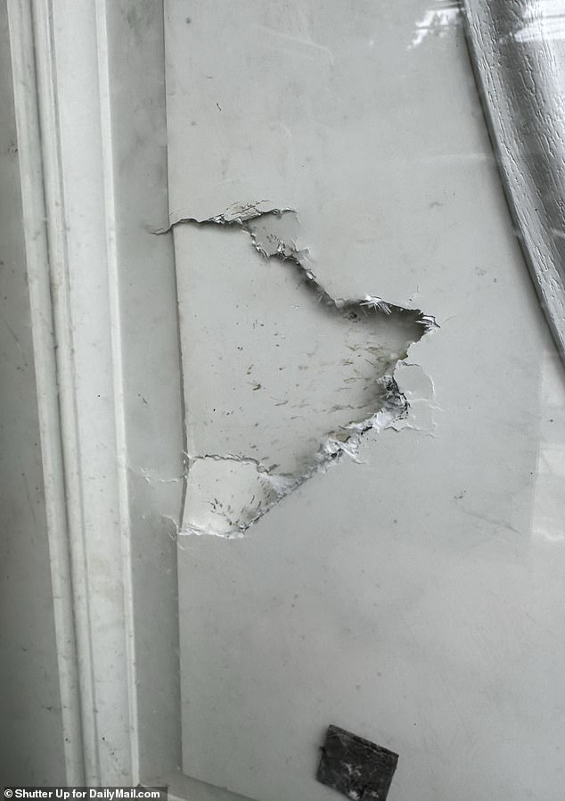 A broken door was visible at the Amityville property raided by police on Monday