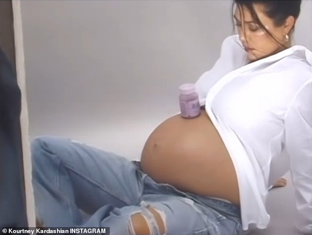 The star bared her baby bump in a white top and jeans
