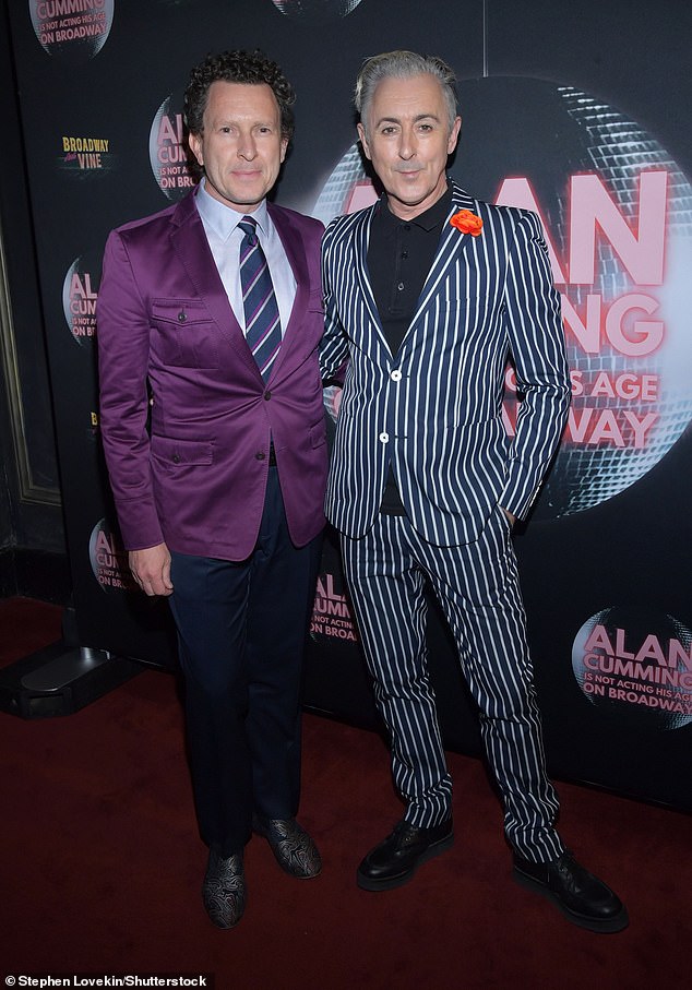 Cumming posed with Jacob Langfelder, who wore an eye-catching purple blazer