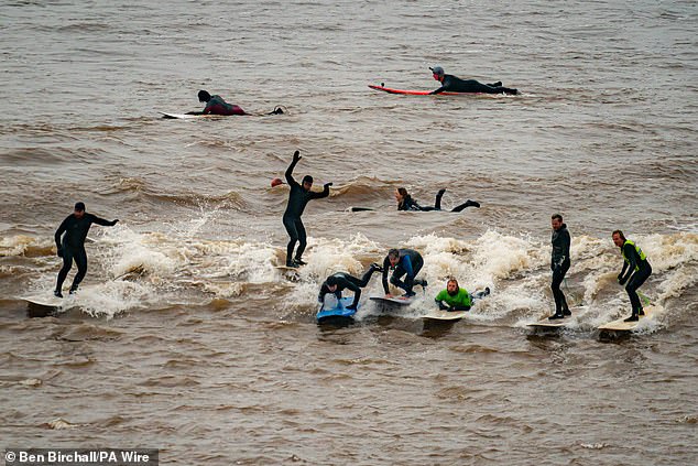 Dozens of surfers and paddleboarders tried to ride the wave - with varying degrees of success