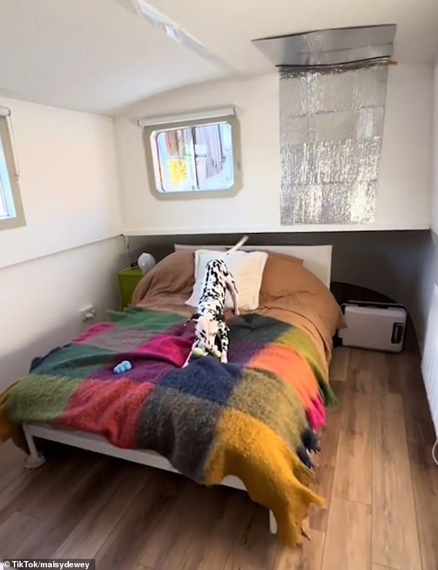 The interior of the boat is bright and cheerful, and they have a spacious double bedroom (pictured, with Kipper in bed).
