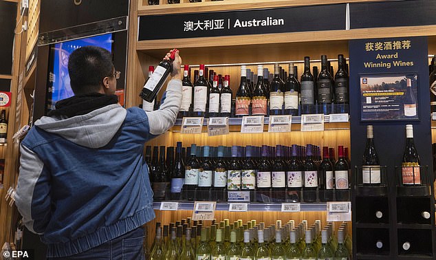 Beijing will announce its final decision later this month, but the move has raised hopes that the tariffs will be removed entirely (pictured, bottles on display in Shanghai)