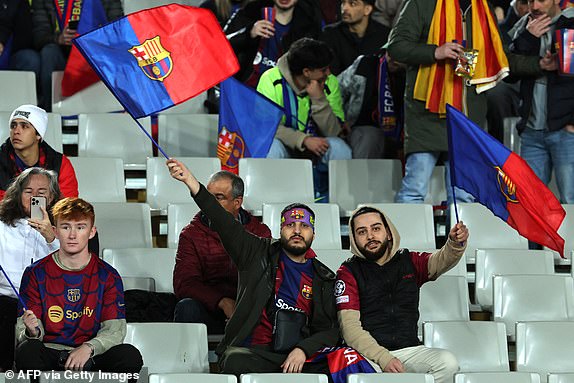 Barcelona fans wave flags as they wait for the start of the second leg of the UEFA Champions League last 16 match between FC Barcelona and SSC Napoli at the Estadi Olimpic Lluis Companys in Barcelona on March 12, 2024. (Photo by LLUIS GENE/AFP) (Photo by LLUIS GENE/AFP via Getty Images)
