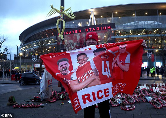 An Arsenal fan holds a flag depicting Arsenal's Declan Rice outside the stadium before the UEFA Champions League round of 16 second leg match between Arsenal and Porto in London, UK on March 12 2024. EPA/NEIL HALL