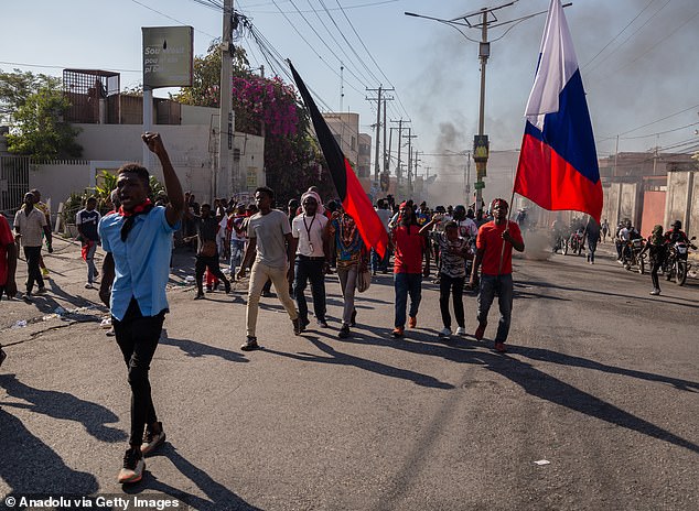 People carrying Haitian flags march during a demonstration demanding the resignation of Haitian Prime Minister Ariel Henry on Wednesday.