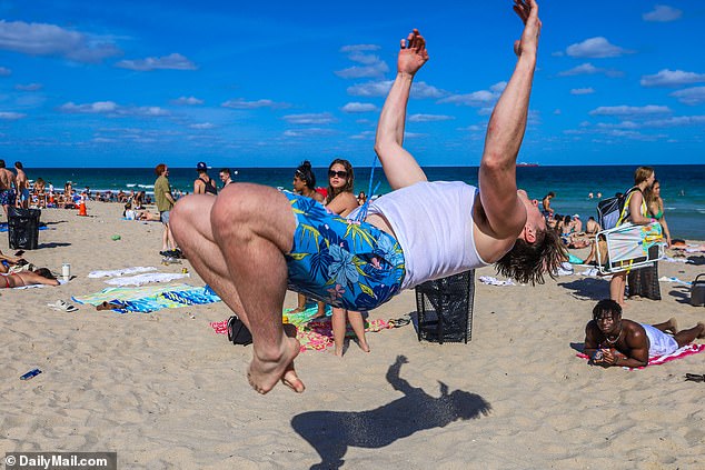 A spring breaker does a backflip at Las Olas Beach in Fort Lauderdale
