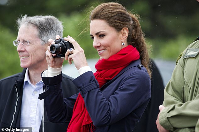 Catherine, then Duchess of Cambridge, takes pictures as Prince William takes part in helicopter maneuvers over Lake Dalvay in 2011