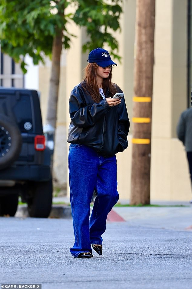 Once again, she was casually cool in an oversized black leather jacket, a navy blue baseball cap, a pair of sunglasses and the same jeans and shoes
