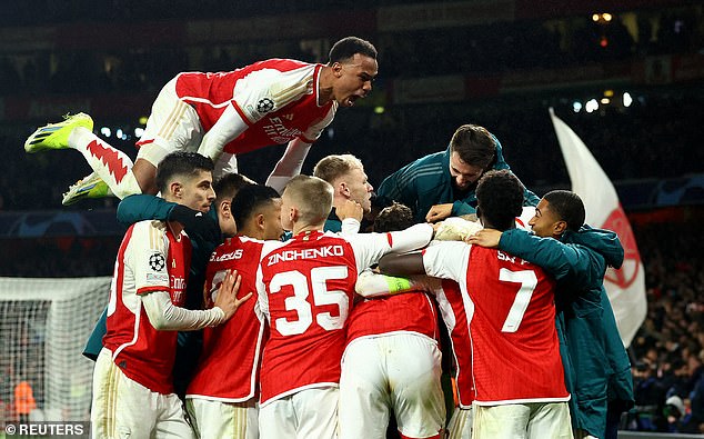 Gunners players swarmed Raya after Spaniard kept Champions League hopes alive