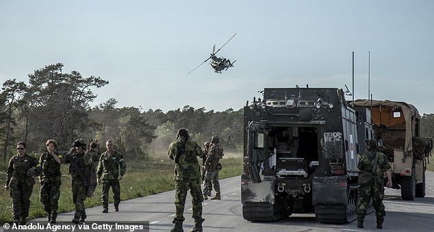U.S. and Swedish troops evacuate a wounded comrade on a helicopter as they participate in a war simulation in Gotland, Sweden, June 9, 2022