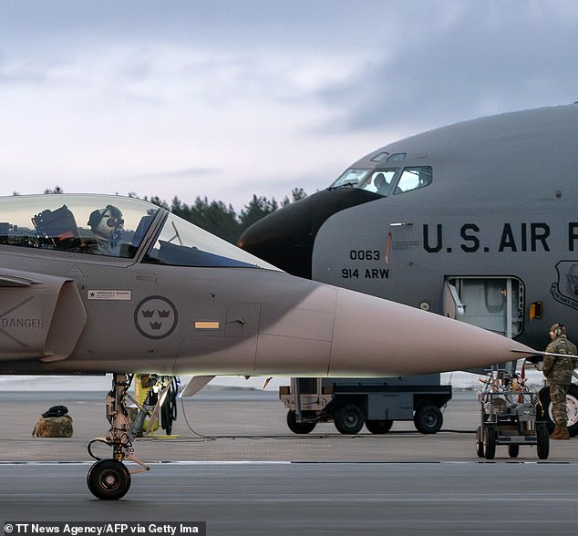 A JAS 39 Gripen C/D fighter jet of the Swedish Armed Forces taxis past a US KC-135 Stratotanker military tanker at Lulea-Kallax Airport, Sweden on March 4, 2024 during the NATO Nordic Response 24 military exercise