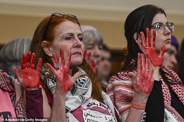 A group of activists organized a pro-Palestinian protest at the House hearing, raising their hands painted red, calling for a ceasefire in Gaza and wearing Palestinian keffiyehs