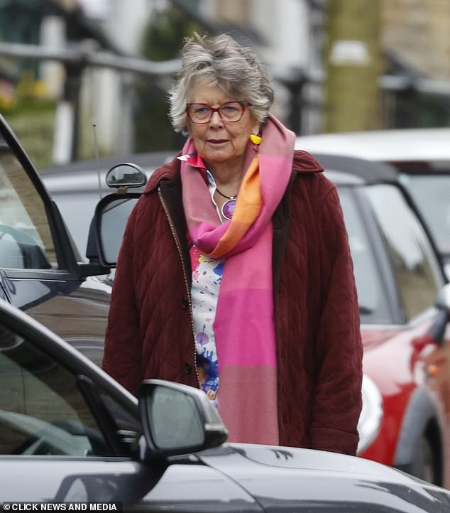 The 84-year-old paired the scarf with a deep red quilted coat and a paint-splattered patterned colorful blouse