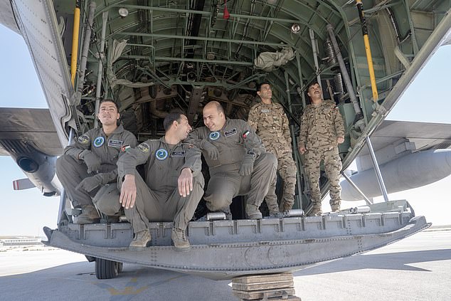 Jordanian airmen take a break between loading humanitarian aid onto a C-130 at King Abdullah II Air Base