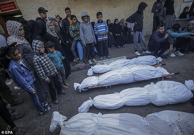 Relatives of the Al Atrash family mourn their covered bodies at Al Aqsa Hospital after an Israeli airstrike in Deir Al Balah