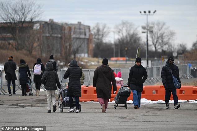 Newly arrived migrants are pictured walking outside the Floyd Bennett Field shelter on February 21, 2024 in Brooklyn