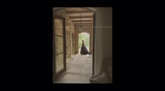 The video continues with a shot of a woman in a long dress, backlit through an Italian-style corridor leading outside.