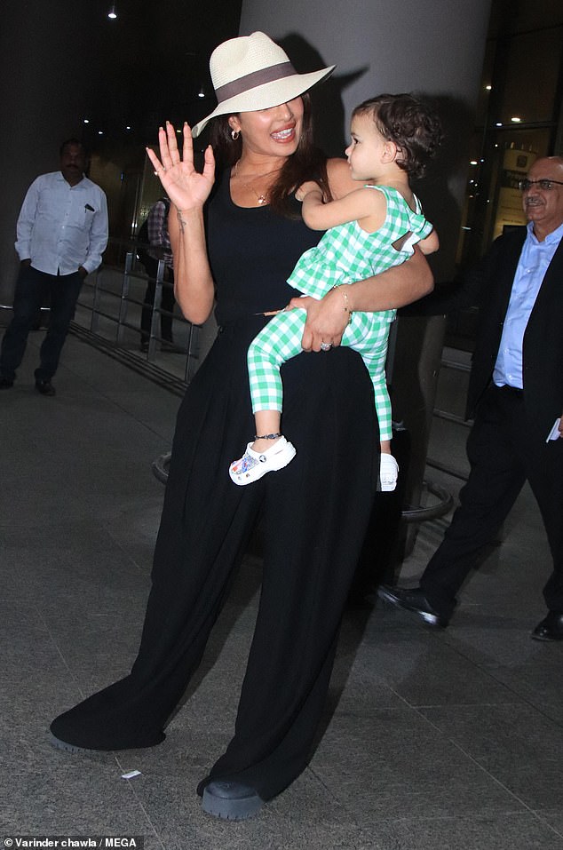 Malti looked adorable in a green and white gingham dress as she held onto her beaming mother