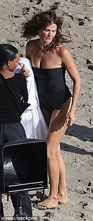 The 55-year-old looked fit in a black one-piece swimsuit as she strolled the sandy shores
