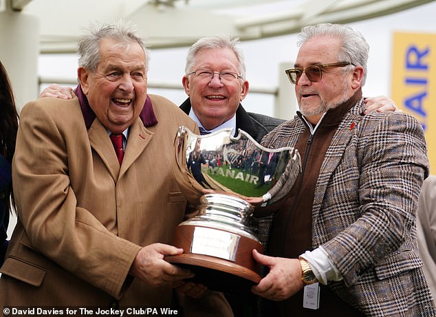 Part-owners John Hales (left) and Sir Alex Ferguson (centre) celebrate with the trophy after Prokectorat won the Ryanair Steeple Chase