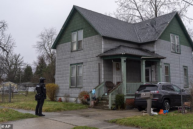 A member of the Saginaw Police Department stands guard near a home in Saginaw, Michigan as the president attends a campaign stop at a nearby home