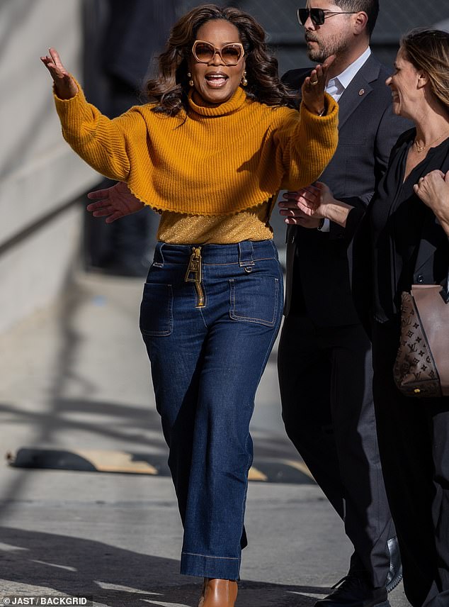 As she entered the studio, Oprah happily threw her arms in the air, causing her top to ride up and emphasizing her reduced frame