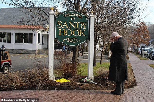 Steve Wruble stands silently and thinks by the Sandy Hook town sign after shootings at Sandy Hook Elementary School, Newtown, Connecticut, USA.  15 December 2012